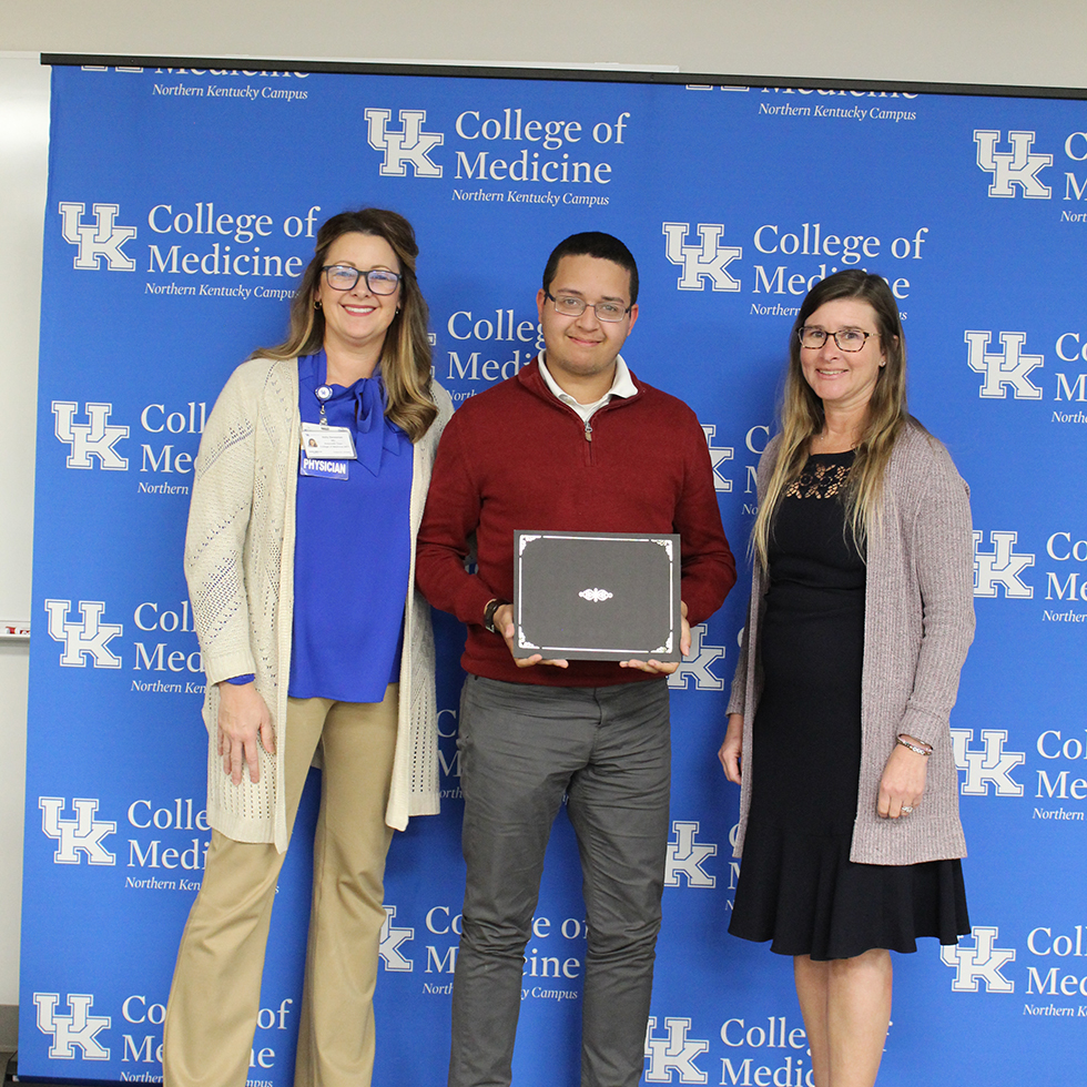 Three people together getting an award